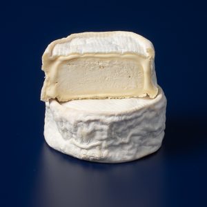 Queso Lía ecológico de leche cruda de vaca, de pasta blanda y muy cremoso, presentado entero y con una mitad abierta mostrando su interior.